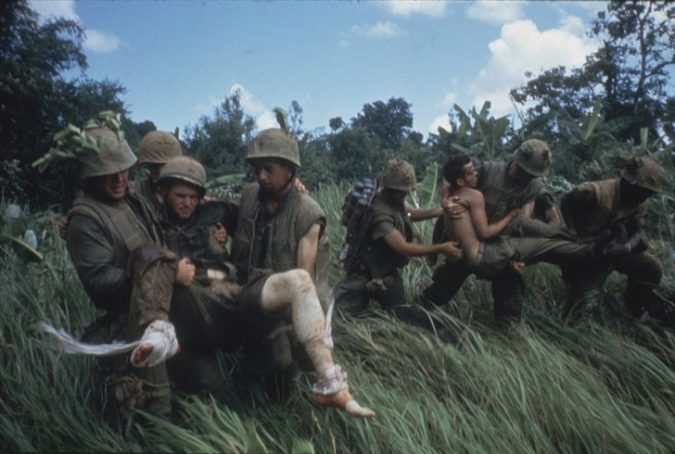Marines carrying their wounded during firefight near the DMZ. 1966.